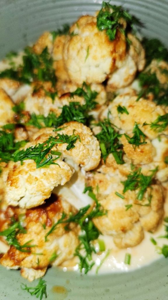 <p>
This roasted cauliflower is packed with umami flavor from miso paste and served over a creamy sauce made with hummus, Greek yogurt, and fresh lime juice. It's simple, healthy, and makes a perfect vegetarian main course or side dish.
</p>
<h2>Ingredients</h2>
<h3>For the cauliflower</h3>
<ul>
<li>1 large head cauliflower, cut into florets</li>
<li>2 tbsp white miso paste</li>
<li>1 tbsp olive oil</li>
<li>1 tbsp soy sauce</li>
<li>1 tsp honey or maple syrup</li>
<li>1 tbsp water</li>
<li>Freshly ground black pepper</li>
</ul>
<h3>For the hummus-lime sauce</h3>
<ul>
<li>150 g hummus</li>
<li>150 g Greek yogurt</li>
<li>Juice of 1 lime</li>
<li>1 small garlic clove, grated (optional)</li>
<li>2–3 tbsp water, if needed</li>
<li>Salt and black pepper, to taste</li>
</ul>
<h3>For serving</h3>
<ul>
<li>Fresh dill, chopped</li>
<li>Green onions, sliced</li>
<li>Lime wedges</li>
</ul>
<h2>Instructions</h2>
<ol>
<li>
Preheat the oven to 220°C (425°F).
</li>
<li>
In a large bowl, whisk together the miso paste, olive oil, soy sauce, honey, and water until smooth.
</li>
<li>
Add the cauliflower florets and toss until evenly coated.
</li>
<li>
Spread the cauliflower on a baking sheet in a single layer.
</li>
<li>
Roast for 25–30 minutes, turning once halfway through, until golden brown and slightly caramelized around the edges.
</li>
<li>
Meanwhile, prepare the sauce. In a bowl, combine the hummus, Greek yogurt, lime juice, and garlic. Mix until smooth.
</li>
<li>
Add a splash of water if needed to create a creamy, spoonable consistency. Season with salt and pepper to taste.
</li>
<li>
Spread the hummus-lime sauce onto a serving plate or shallow bowl.
</li>
<li>
Pile the roasted cauliflower on top and finish with fresh dill and green onions.
</li>
<li>
Serve warm with extra lime wedges on the side.
</li>
</ol>
<h2>Tips</h2>
<ul>
<li>White miso gives a milder flavor, but red miso works too for a deeper, richer taste.</li>
<li>The sauce can be made ahead and stored in the refrigerator for up to 3 days.</li>
<li>Add toasted nuts or chickpeas for extra crunch.</li>
</ul>
</article>
```